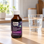 AI-generated lifestyle illustration of Gaia Herbs Organic Black Elderberry Syrup Adult Daily, 3 fl oz on a sunlit pale-oak kitchen counter with a plain water glass.