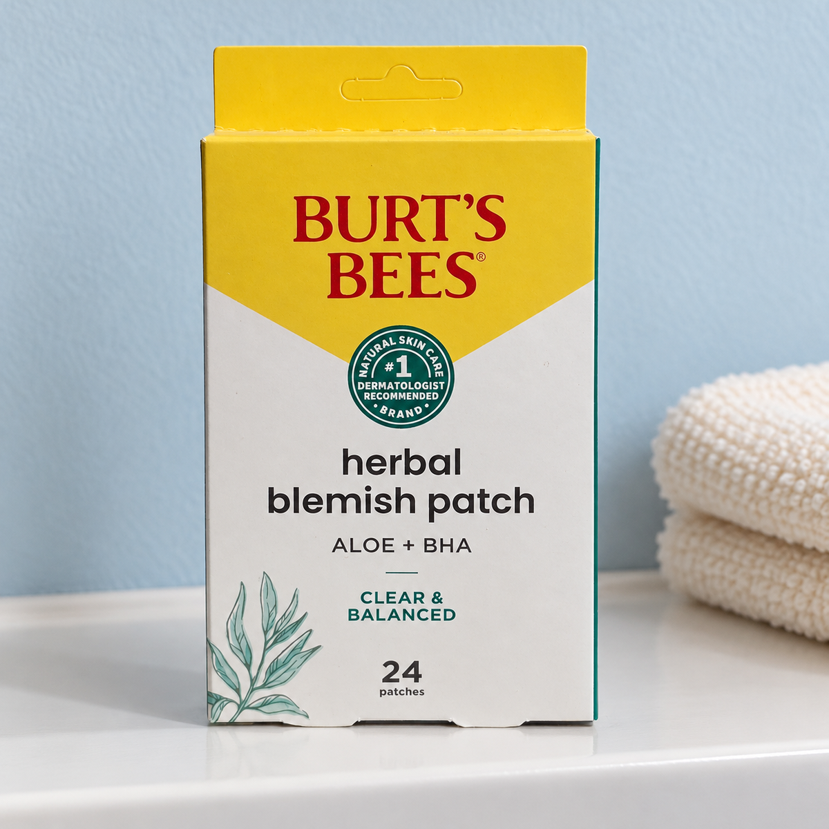 Burt’s Bees Aloe + BHA 24-patch carton on a vanity beside folded towels