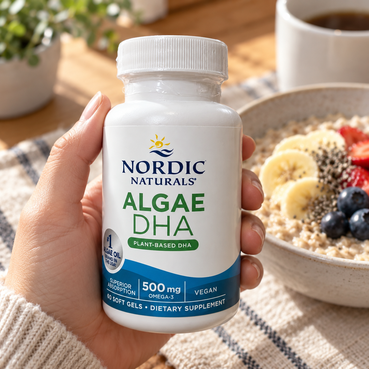An adult holding a Nordic Naturals Algae DHA 60-soft-gel bottle beside a breakfast bowl