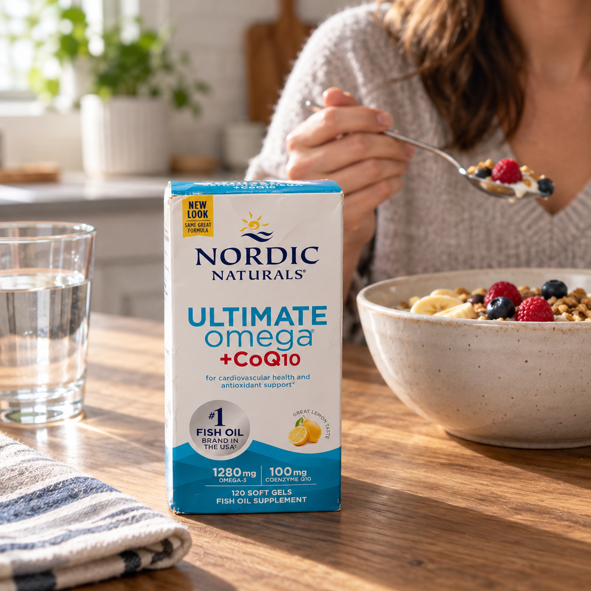 Nordic Naturals Ultimate Omega + CoQ10 120-soft-gel box beside a breakfast bowl and water glass