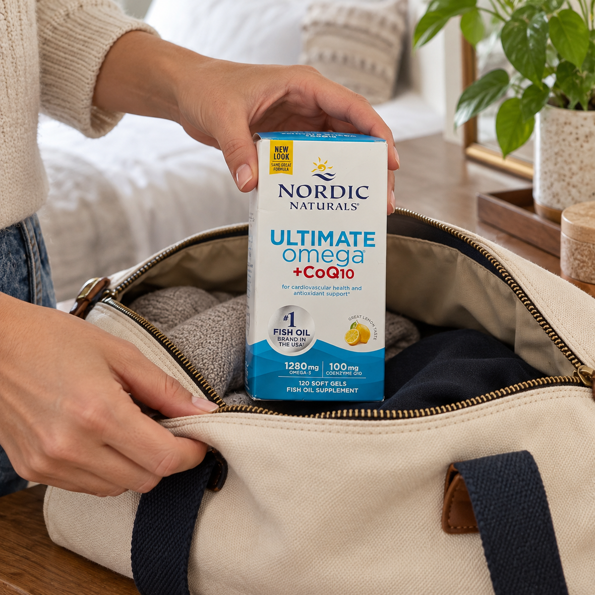 An adult packing the Nordic Naturals Ultimate Omega + CoQ10 120-soft-gel box in a canvas bag