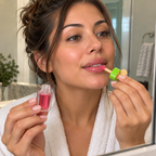 Applying Watermelon Fruit Glow lip oil with its green-capped wand
