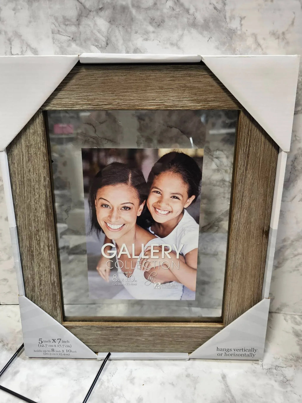 Wooden picture frame with a photo of two people on a marble surface