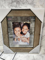 Wooden picture frame with a photo of two people on a marble surface
