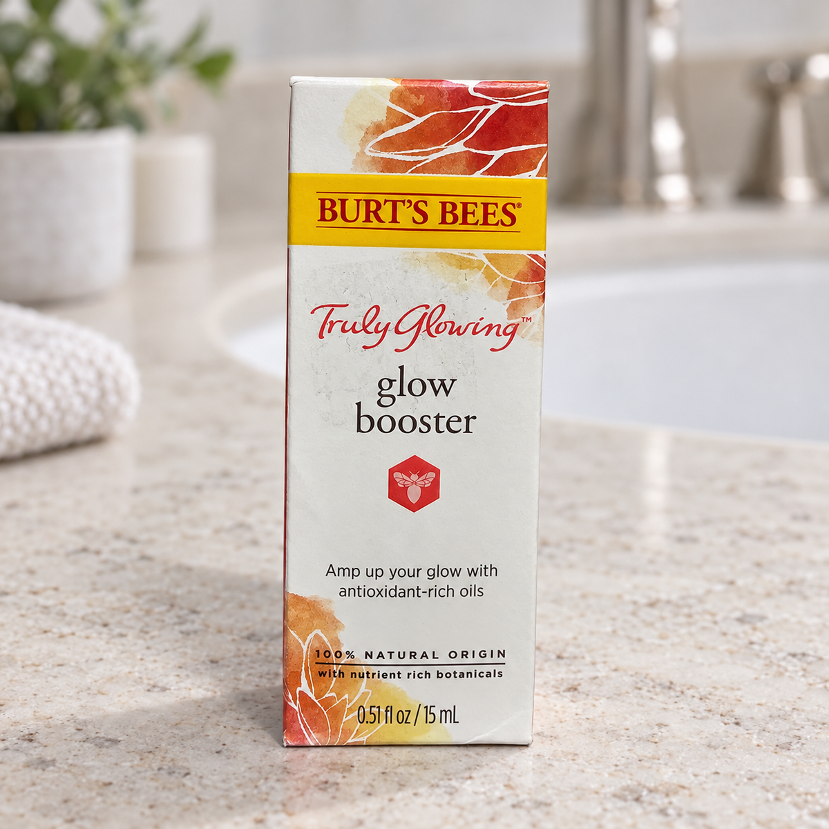 Burt's Bees Truly Glowing Glow Booster carton on a stone vanity, AI-assisted illustration