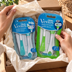 Adult opening a gift containing the green Venus Extra Smooth and teal Extra Smooth Sensitive two-razor packs