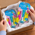Adult unwrapping a gift containing two Venus Tropical three-razor packs