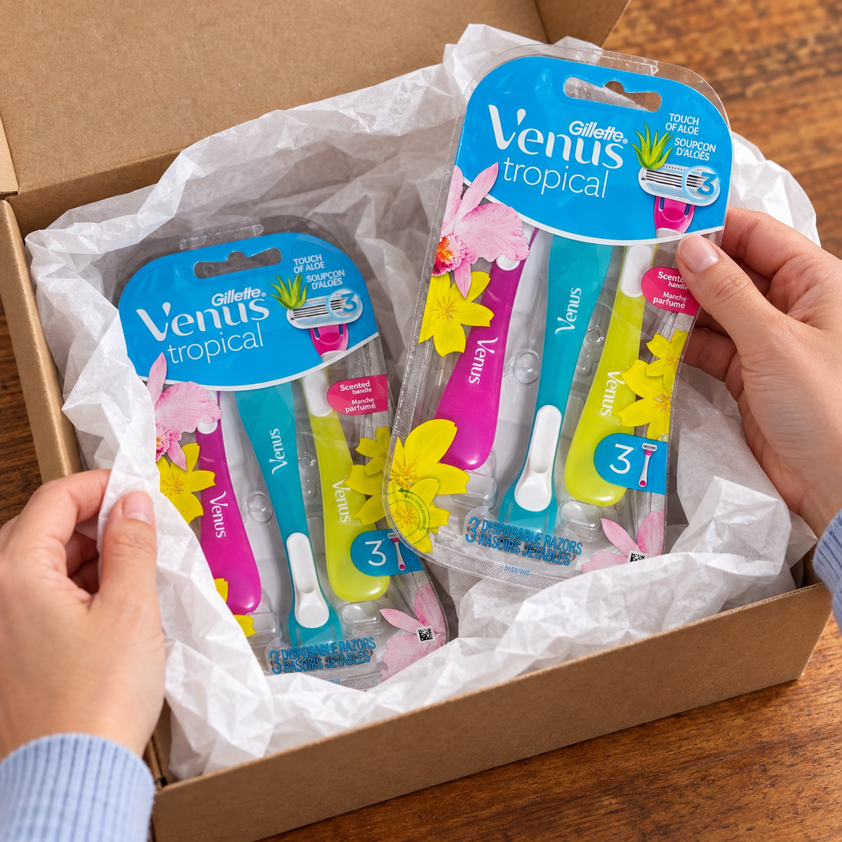 Adult unwrapping a gift containing two Venus Tropical three-razor packs