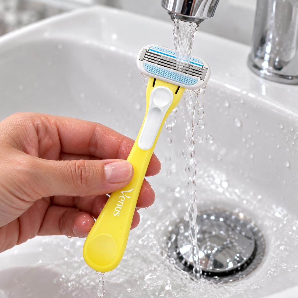 Adult rinsing a yellow Venus Tropical disposable razor under running water