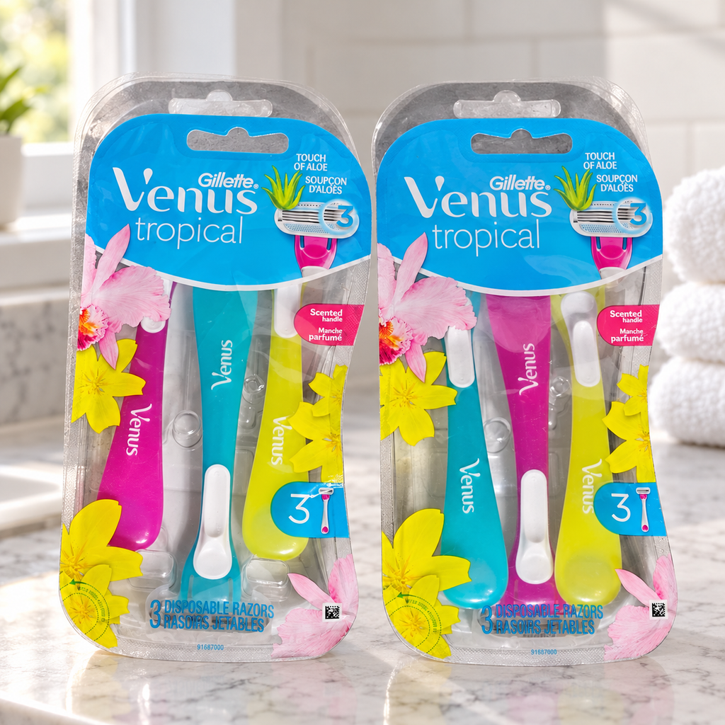 Two Venus Tropical three-razor packs on a marble bathroom counter beside white towels
