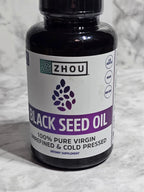 Bottle of Zhou Black Seed Oil on a textured gray background