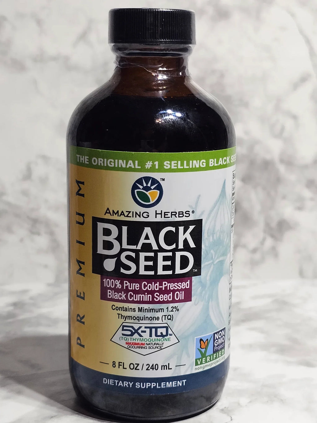Black Seed oil bottle with label on a textured white background