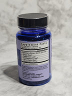Blue supplement bottle with label on a textured gray background