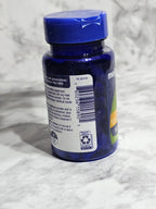 Blue supplement bottle with label on a textured white surface
