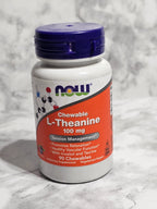 Supplement bottle labeled 'NOW' with a red label on a marble surface