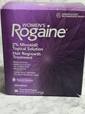 Purple box of Women's Rogaine hair regrowth treatment on a textured surface