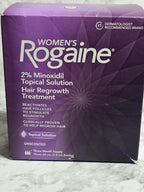 Purple box of Women's Rogaine hair regrowth treatment on a textured surface