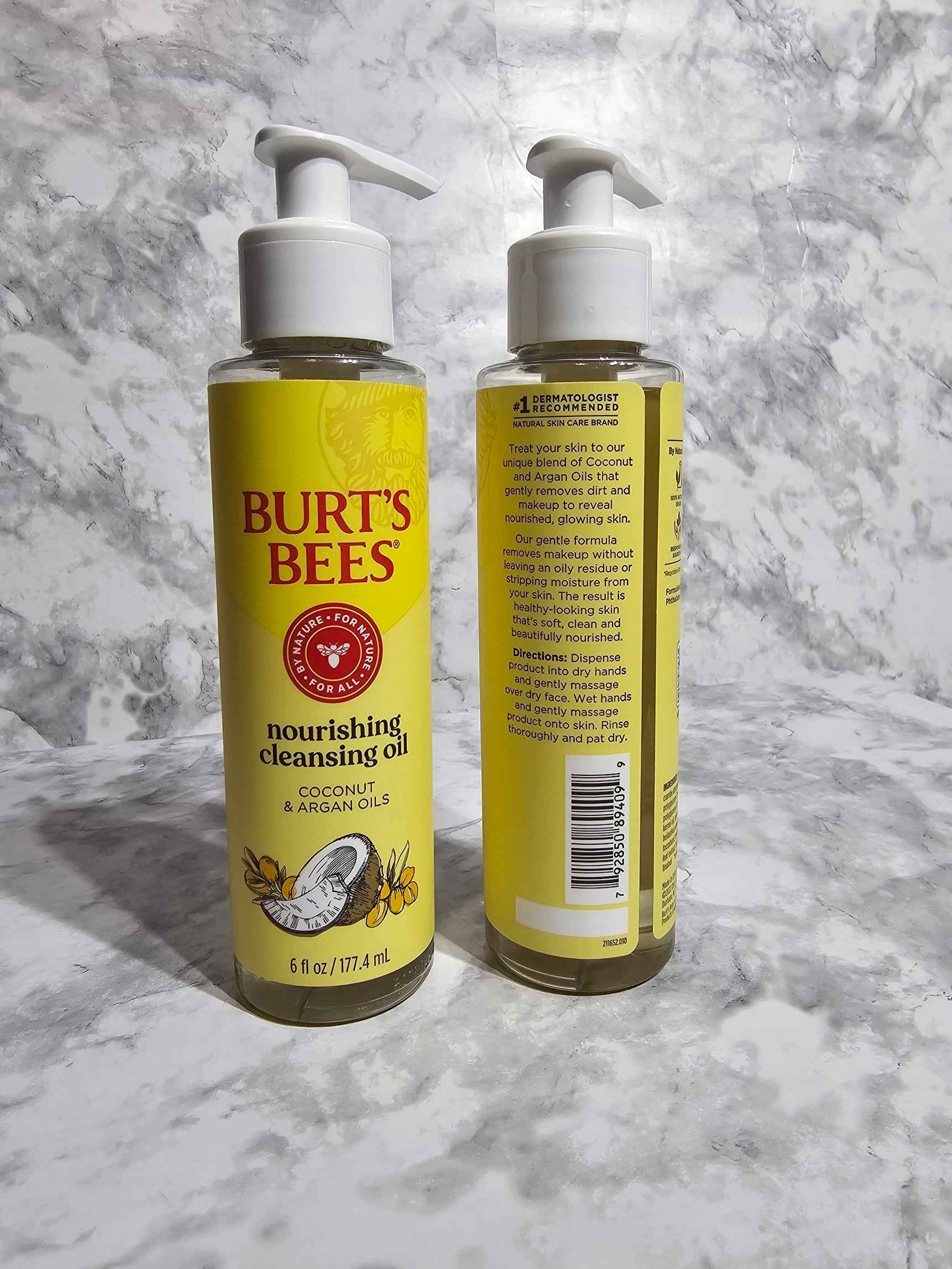 Two bottles of Burt's Bees nourishing cleansing oil on a marble surface