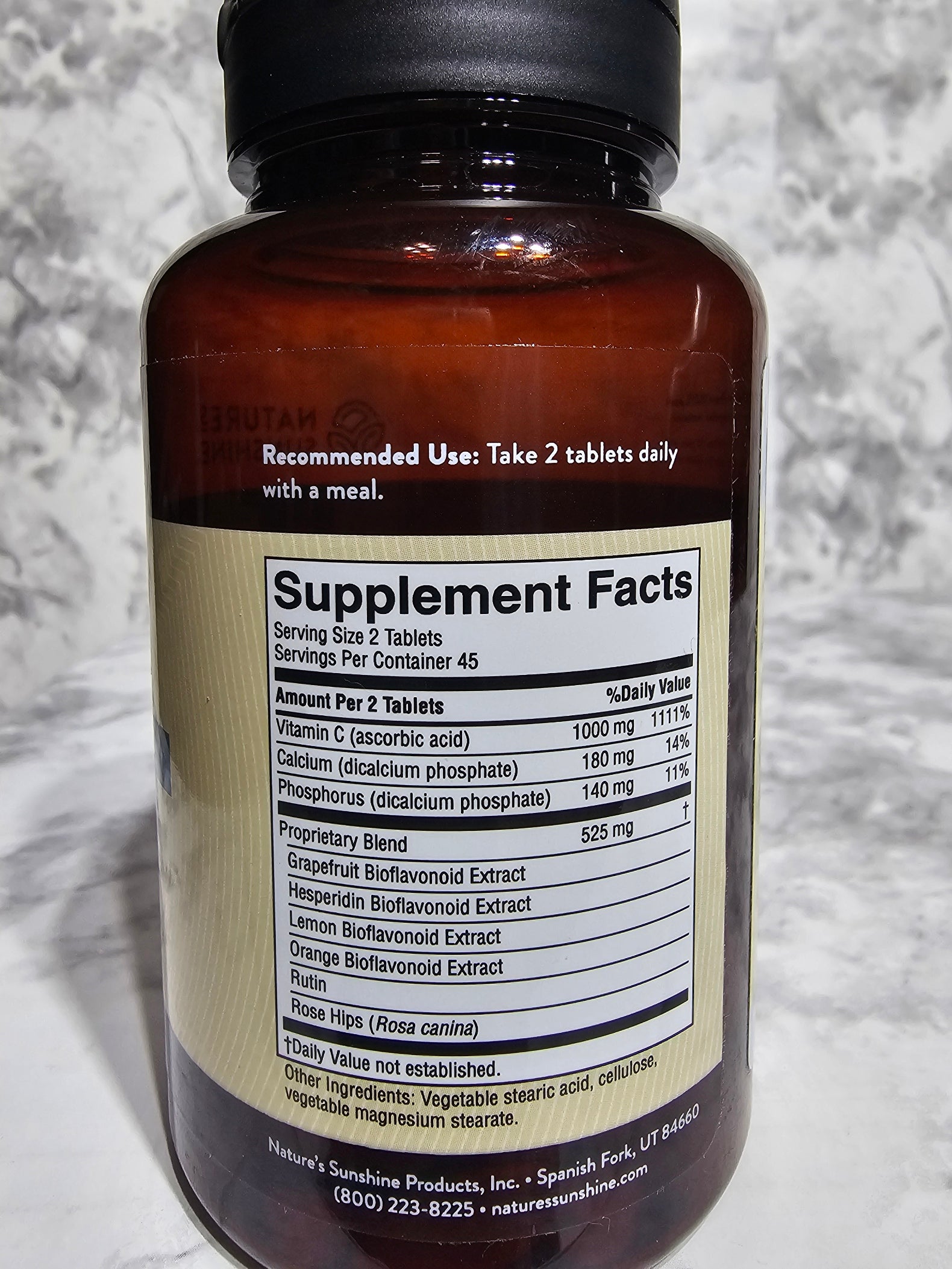 Bottle with supplement label on a marble surface