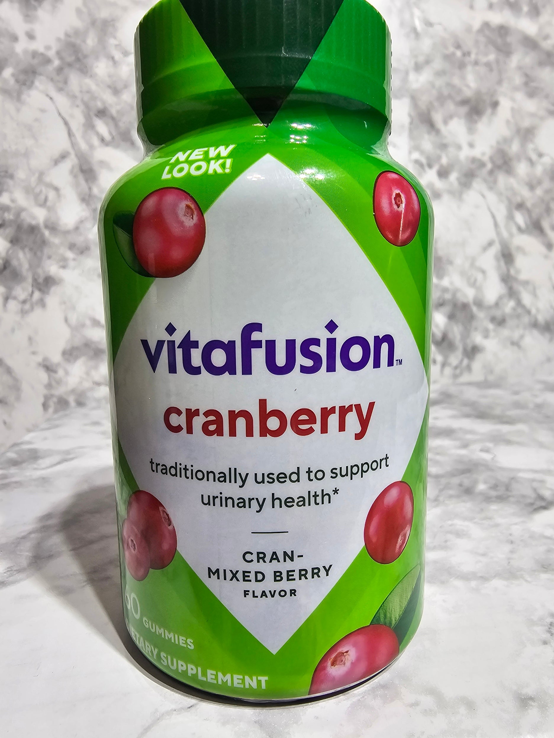 VitaFusion Cranberry supplement bottle on a marble surface