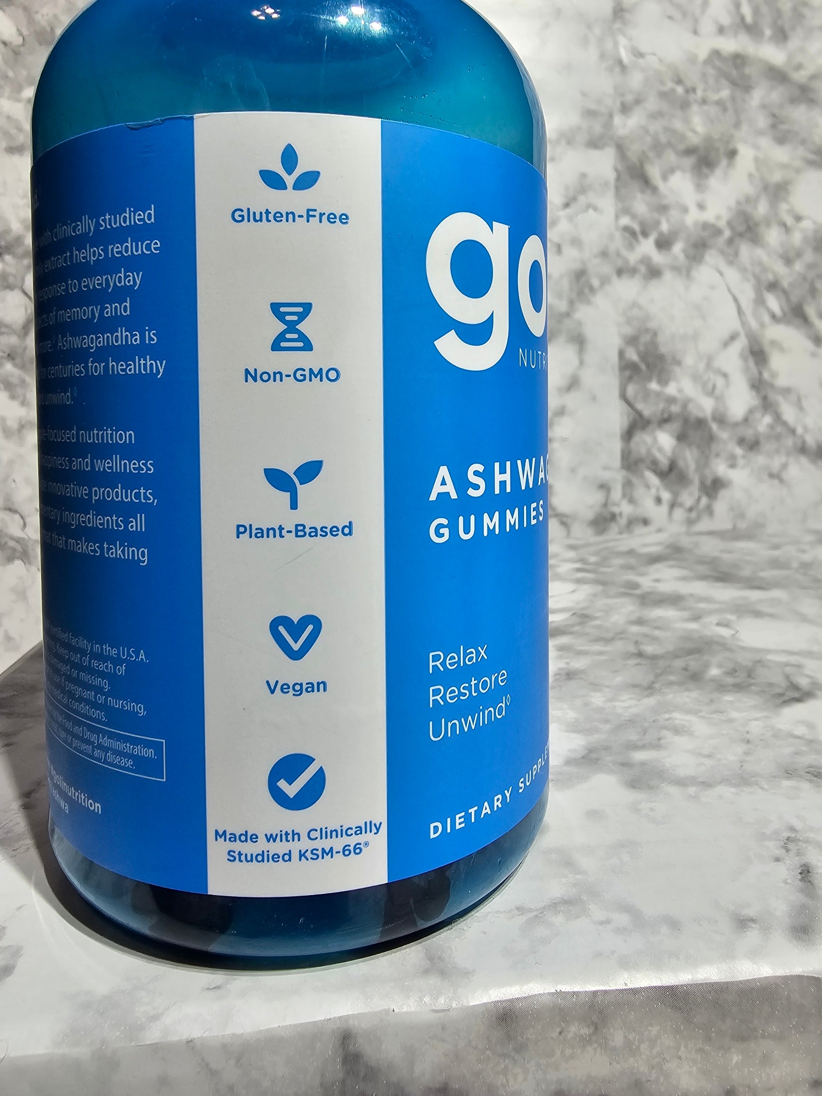 Blue bottle labeled 'go' with a white label on a marble surface