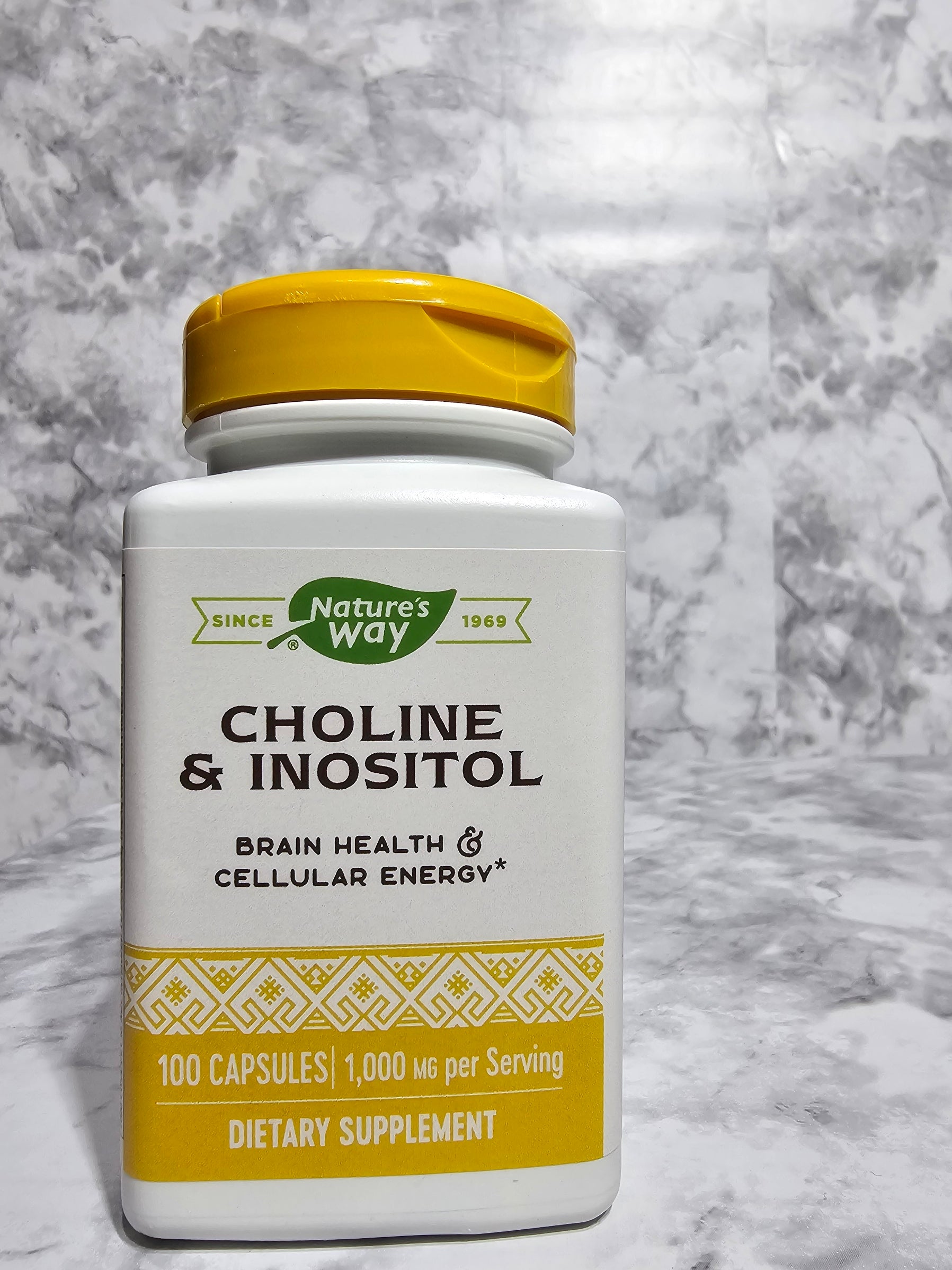 Supplement bottle labeled 'Choline & Inositol' on a marble surface
