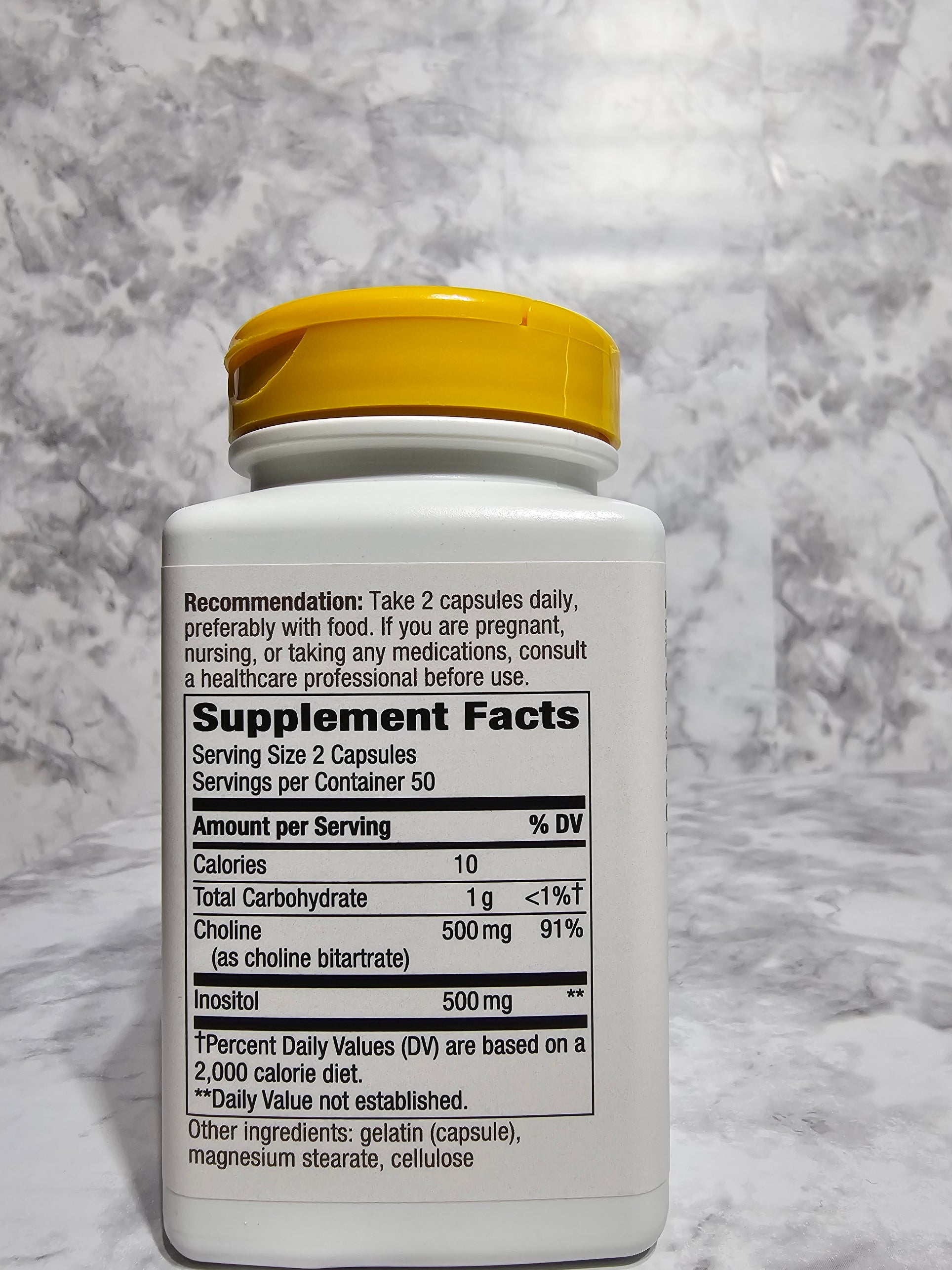 Supplement bottle with label on a gray surface