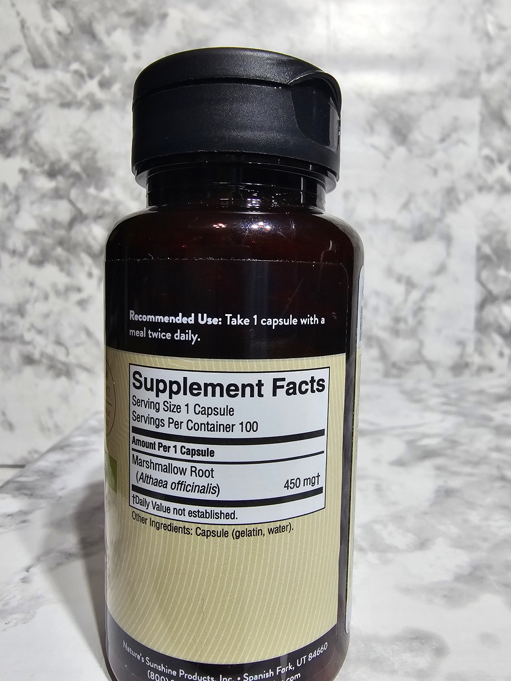 Supplement bottle with label on a marble surface