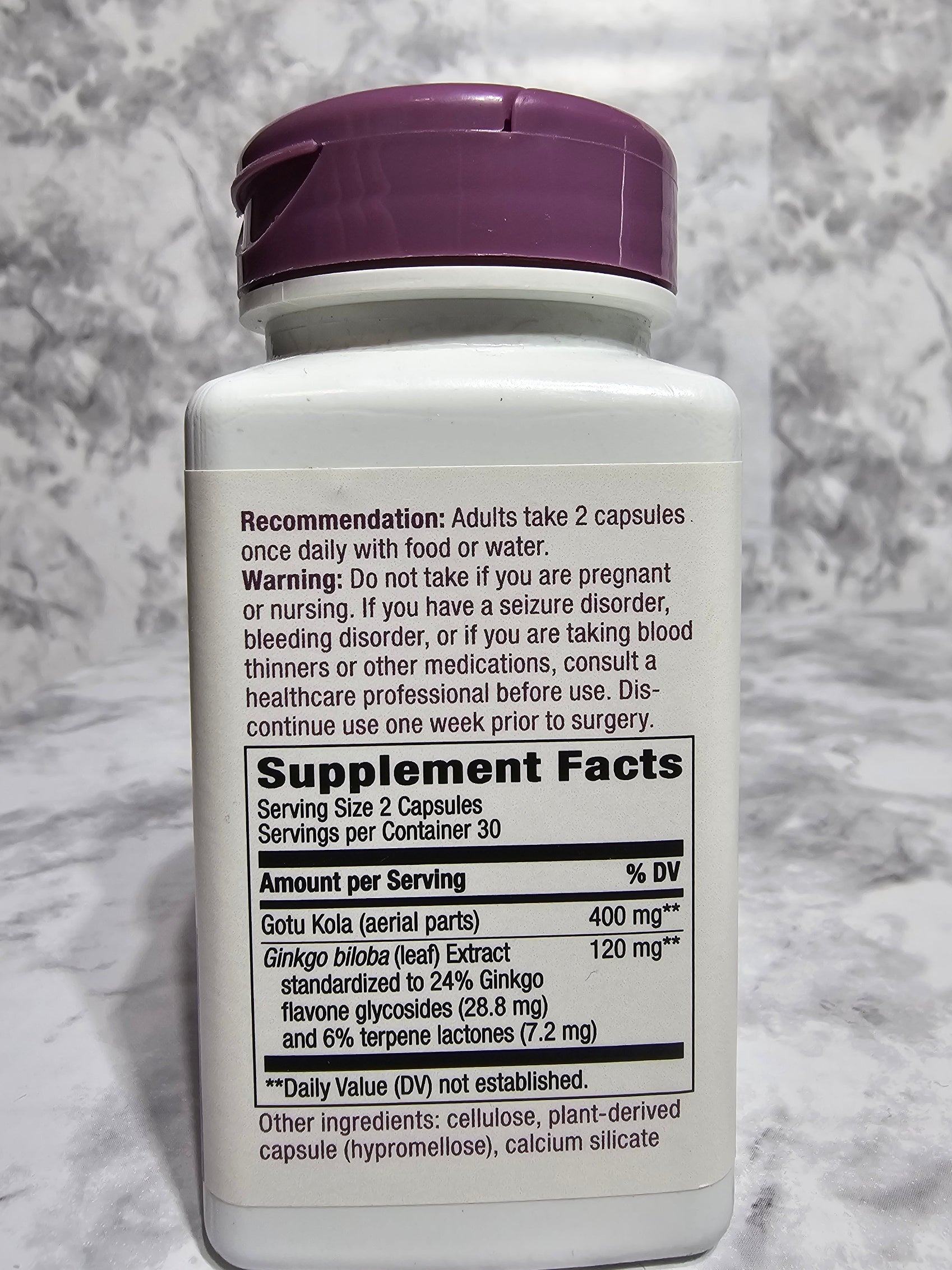 Supplement bottle with label on a gray marble background