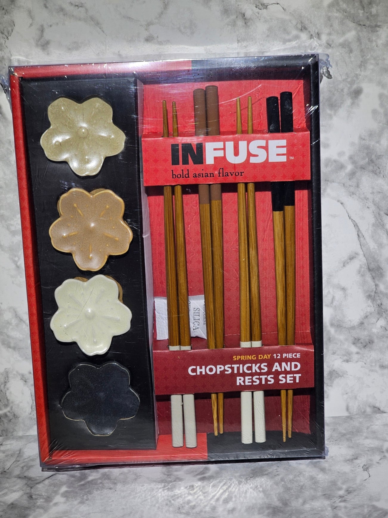 Packaged chopsticks and rests set with 'INFUSE' branding on a marble surface