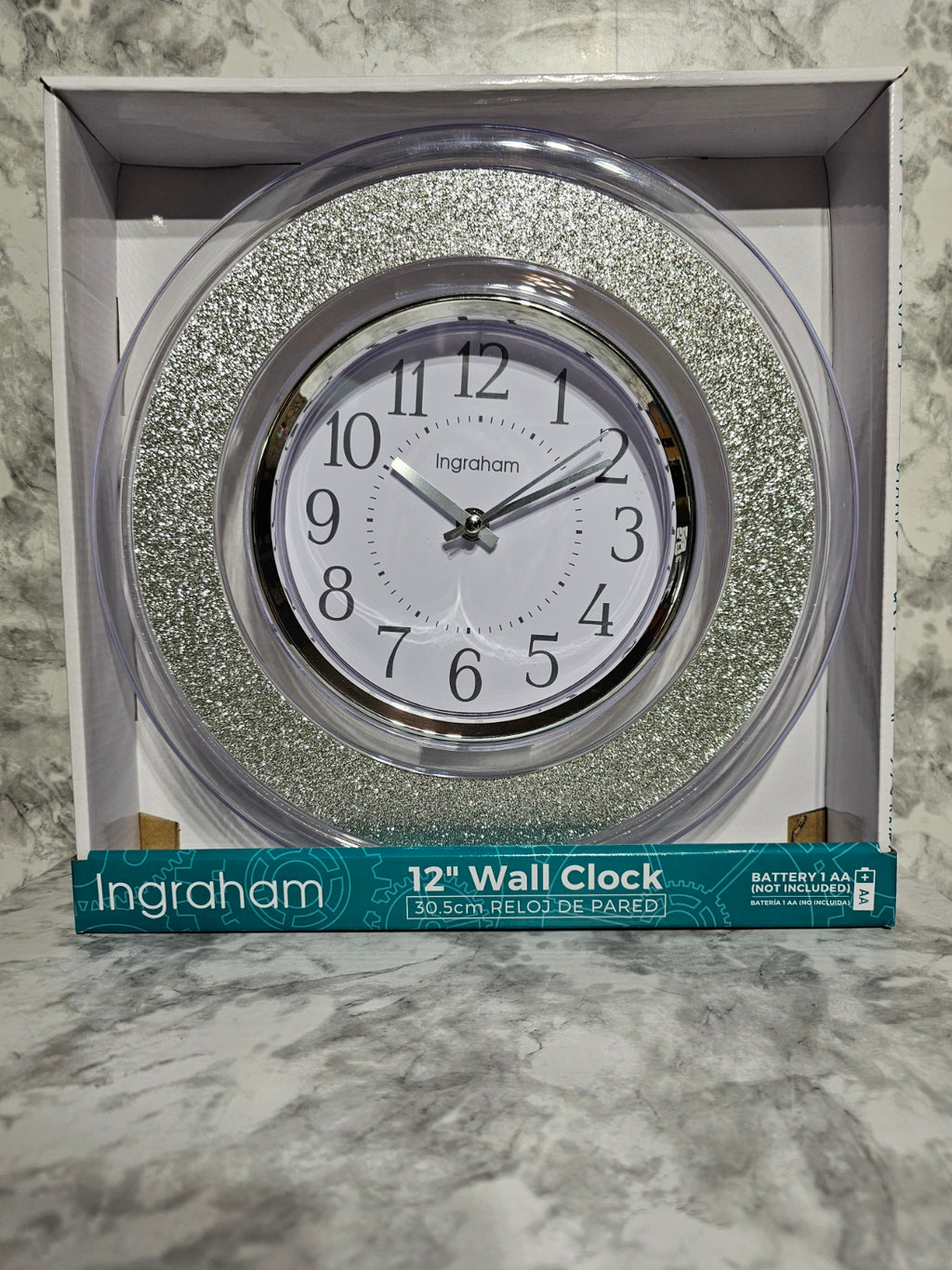 Ingraham wall clock with decorative silver frame in packaging on a marble surface