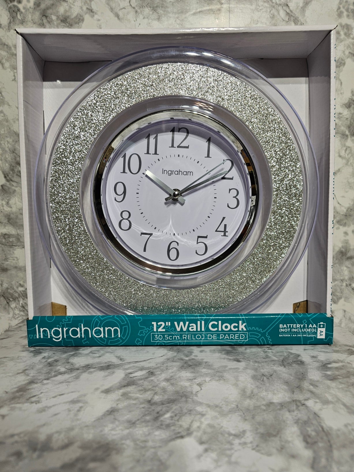 Ingraham wall clock with decorative silver frame in packaging on a marble surface