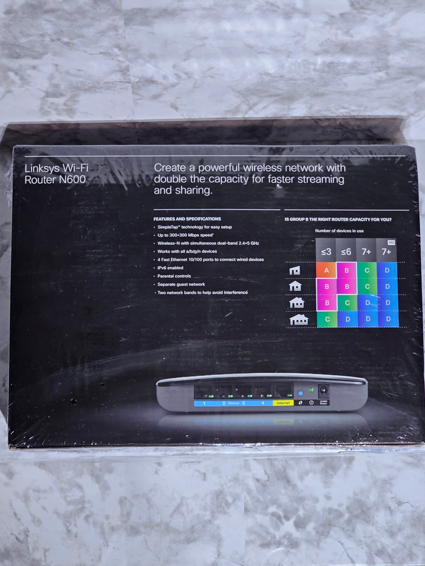 Black router packaging with digital display on a gray surface