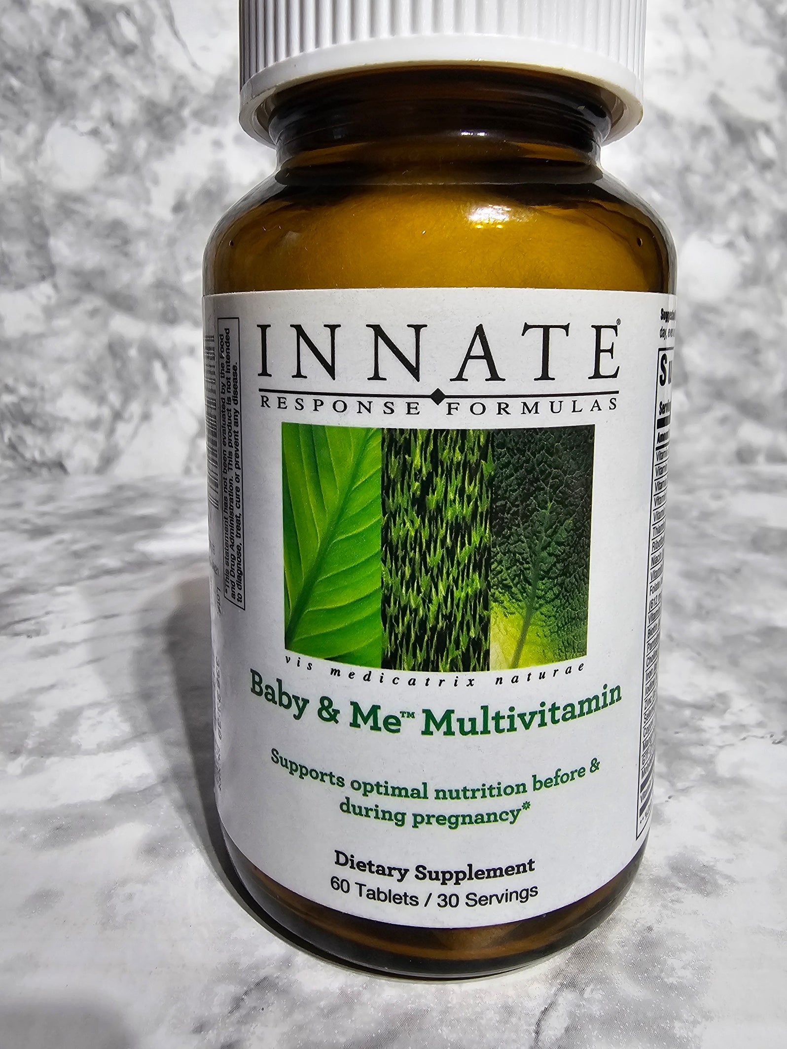 Innate Response Formulas Baby & Me Multivitamin bottle on a marble surface