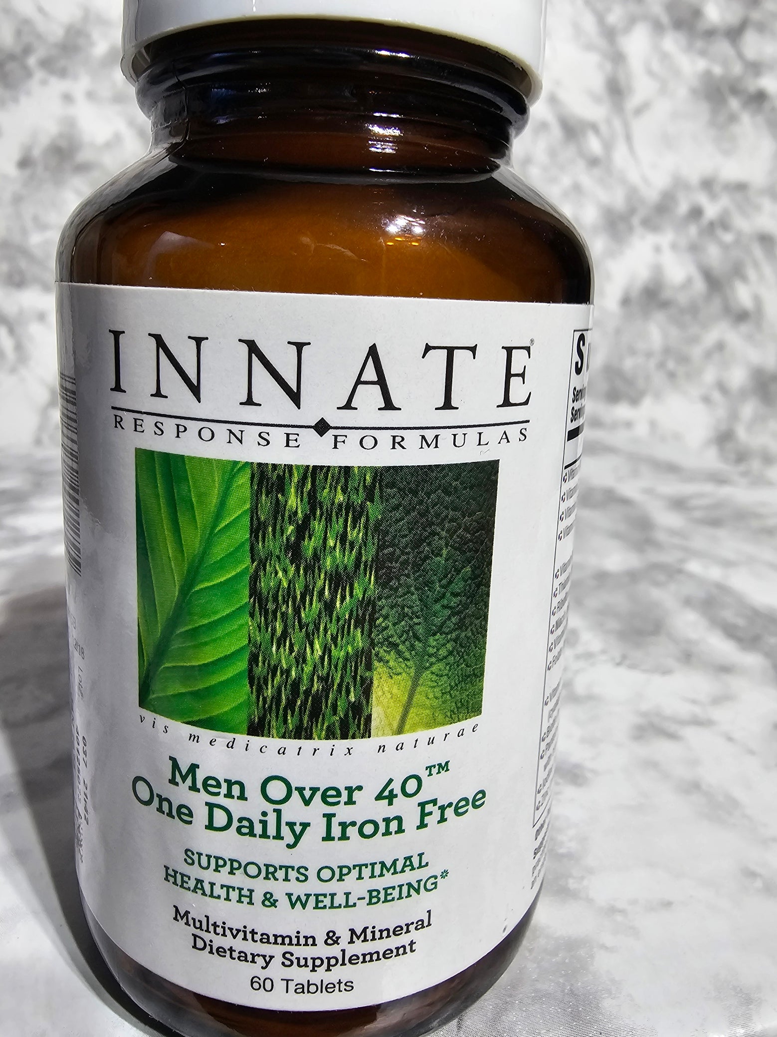 Bottle of Innate Response Formulas dietary supplement with a green leaf graphic on a textured white background