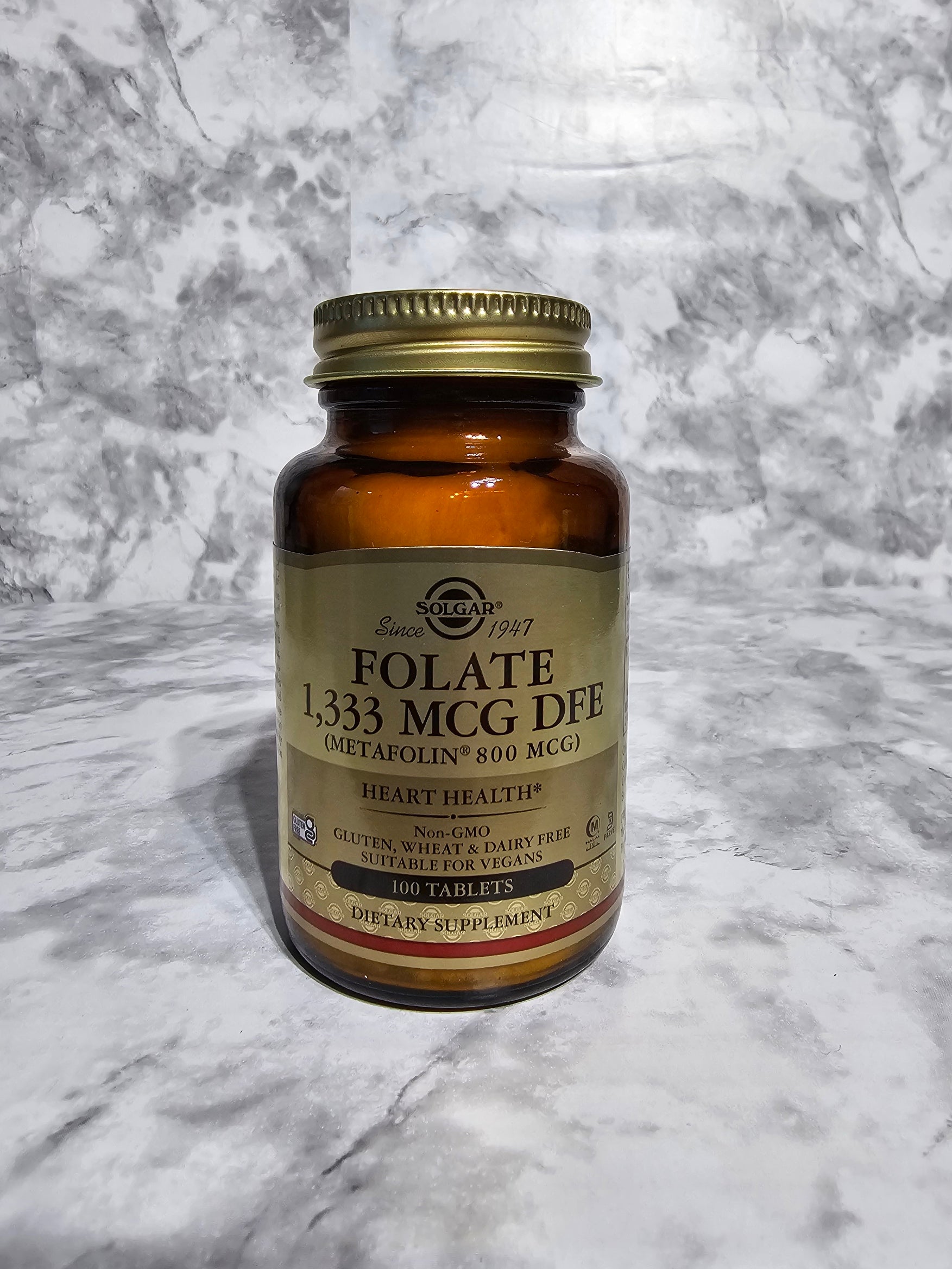 Bottle of Solgar Folate supplement on a marble surface