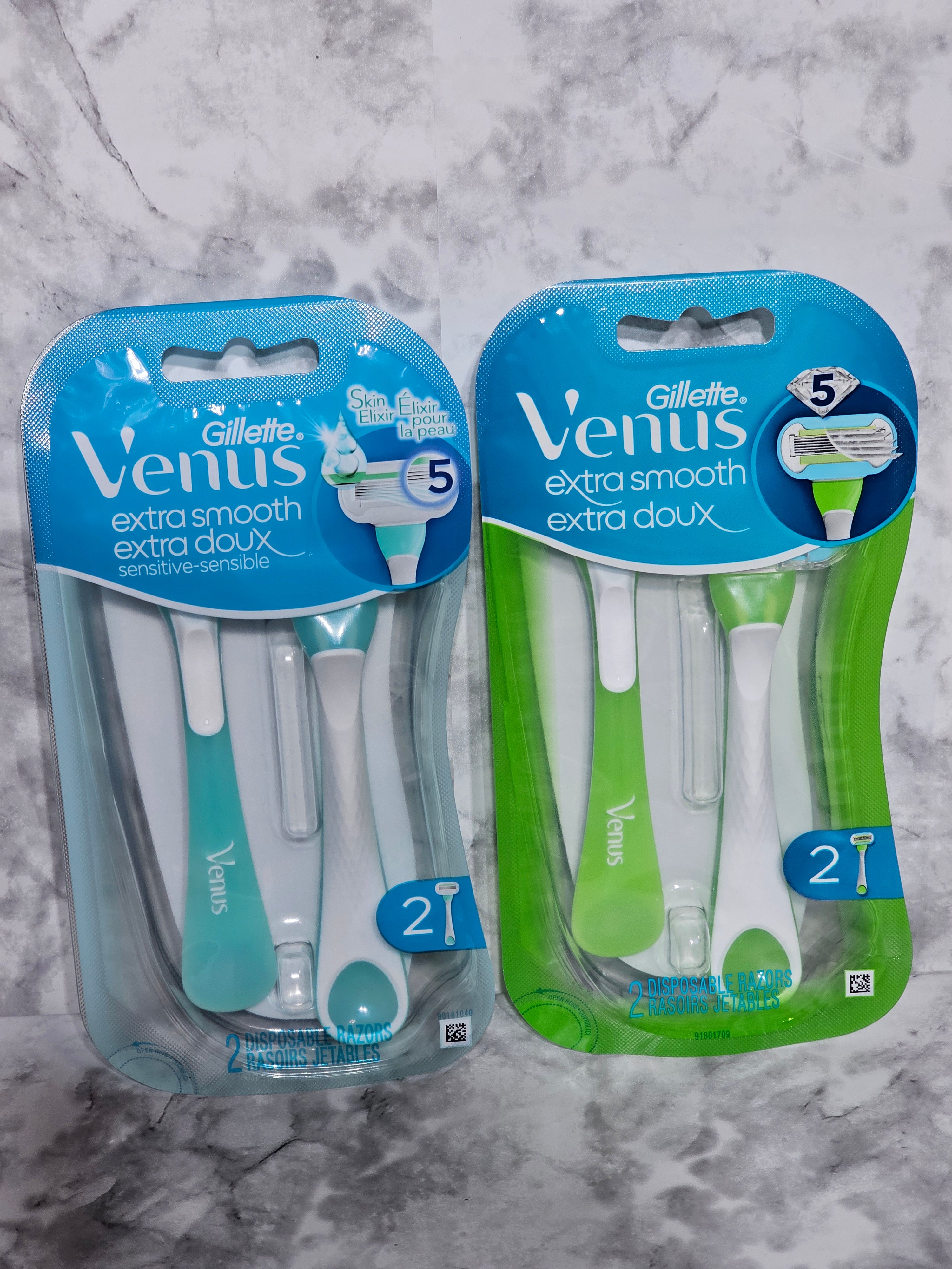 Two packages of Gillette Venus extra smooth razors on a marble surface
