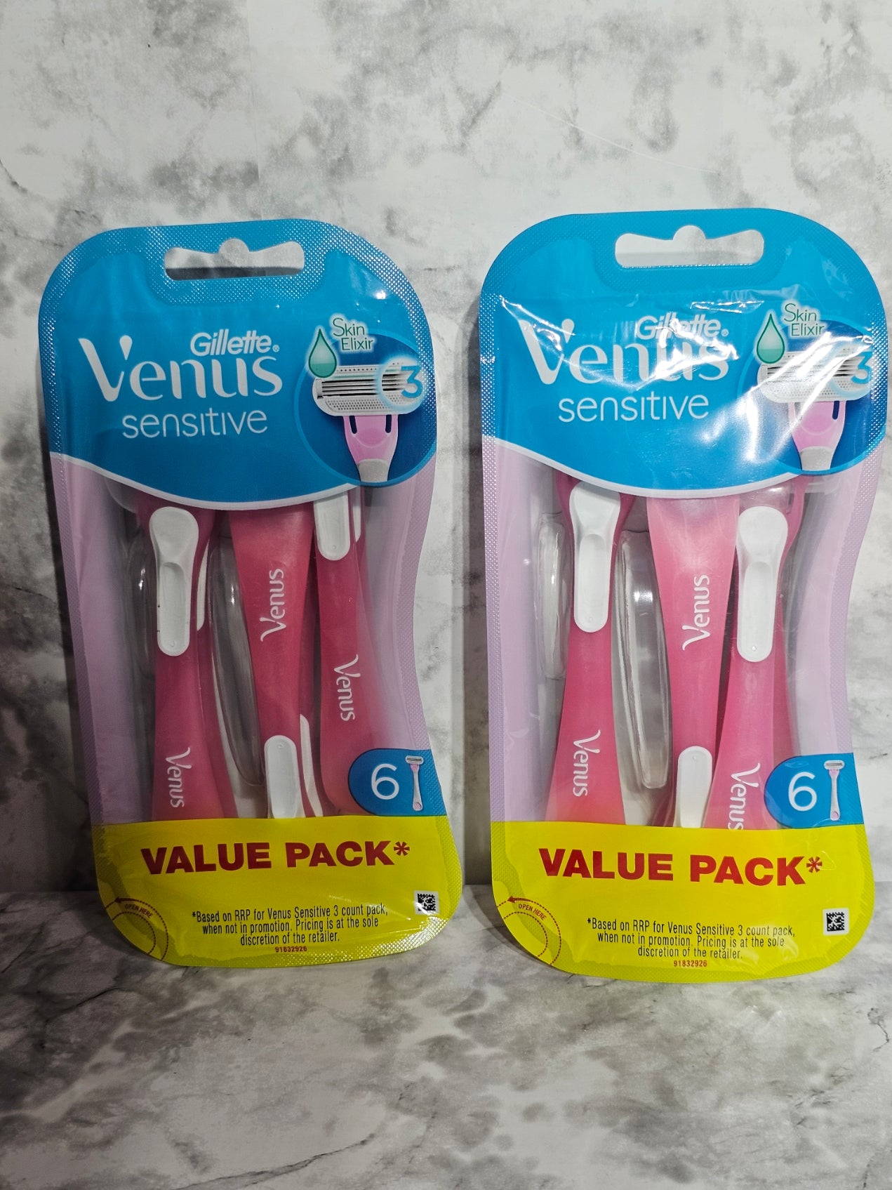 Two packages of Gillette Venus sensitive razors on a marble surface