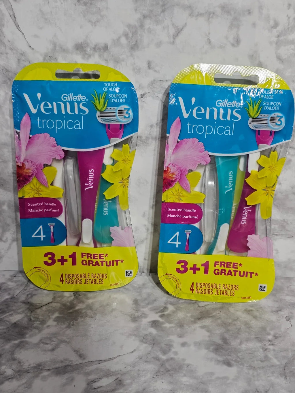 Two packages of Gillette Venus tropical razors on a marble surface