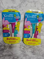 Two packages of Gillette Venus tropical razors on a marble surface