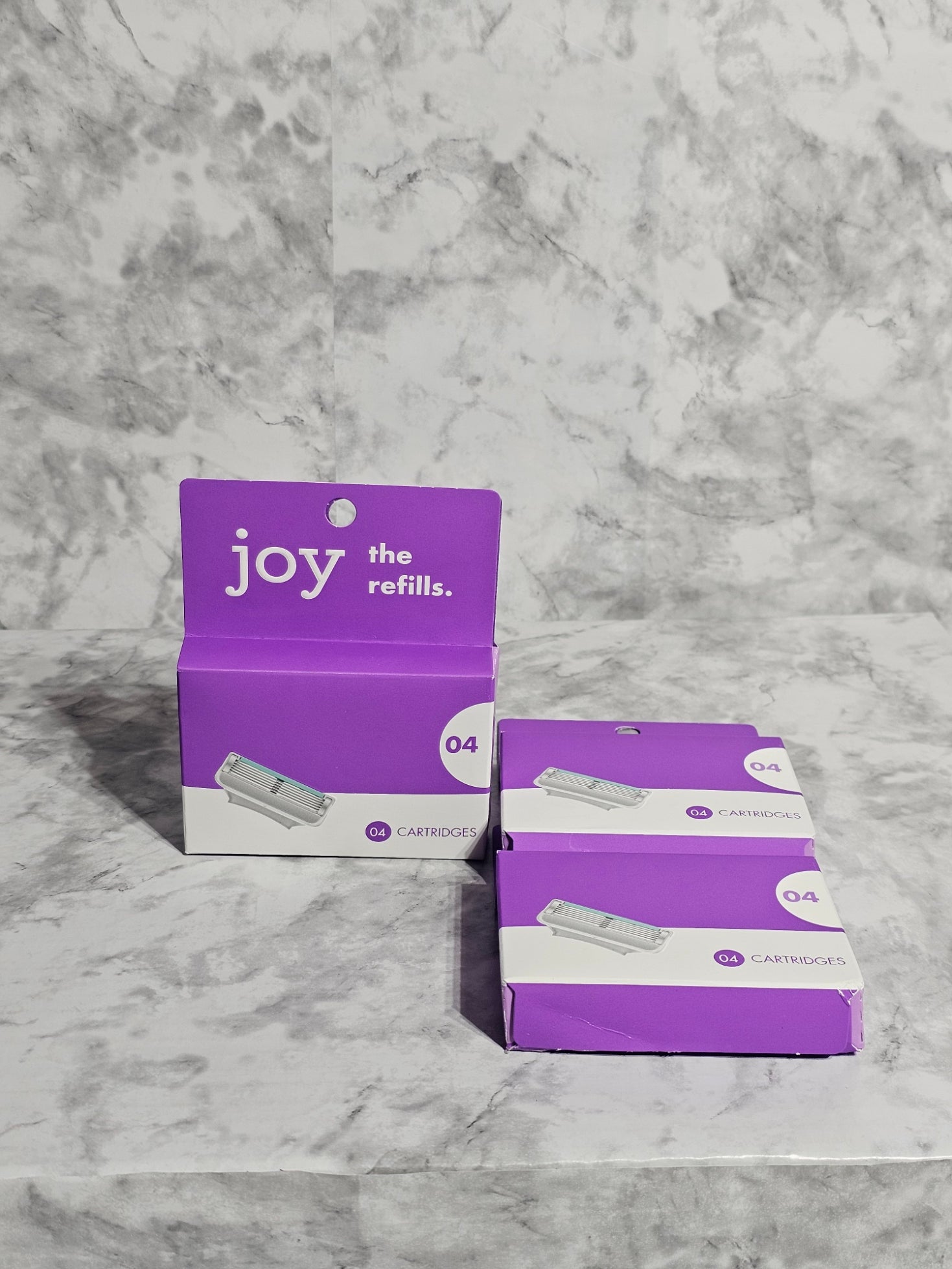 Two purple boxes labeled 'joy' on a marble surface