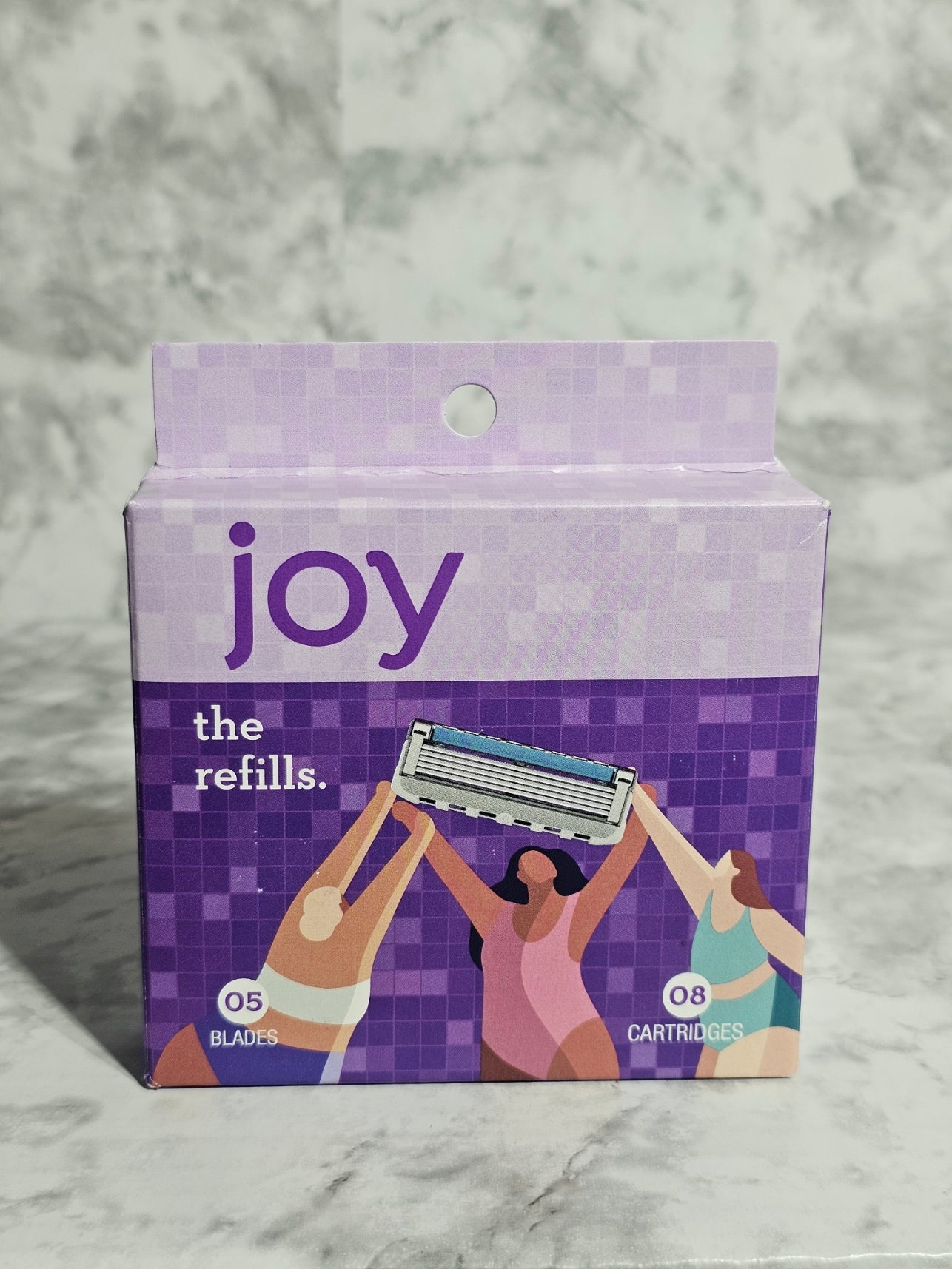 Box of 'joy' refills on a marble background