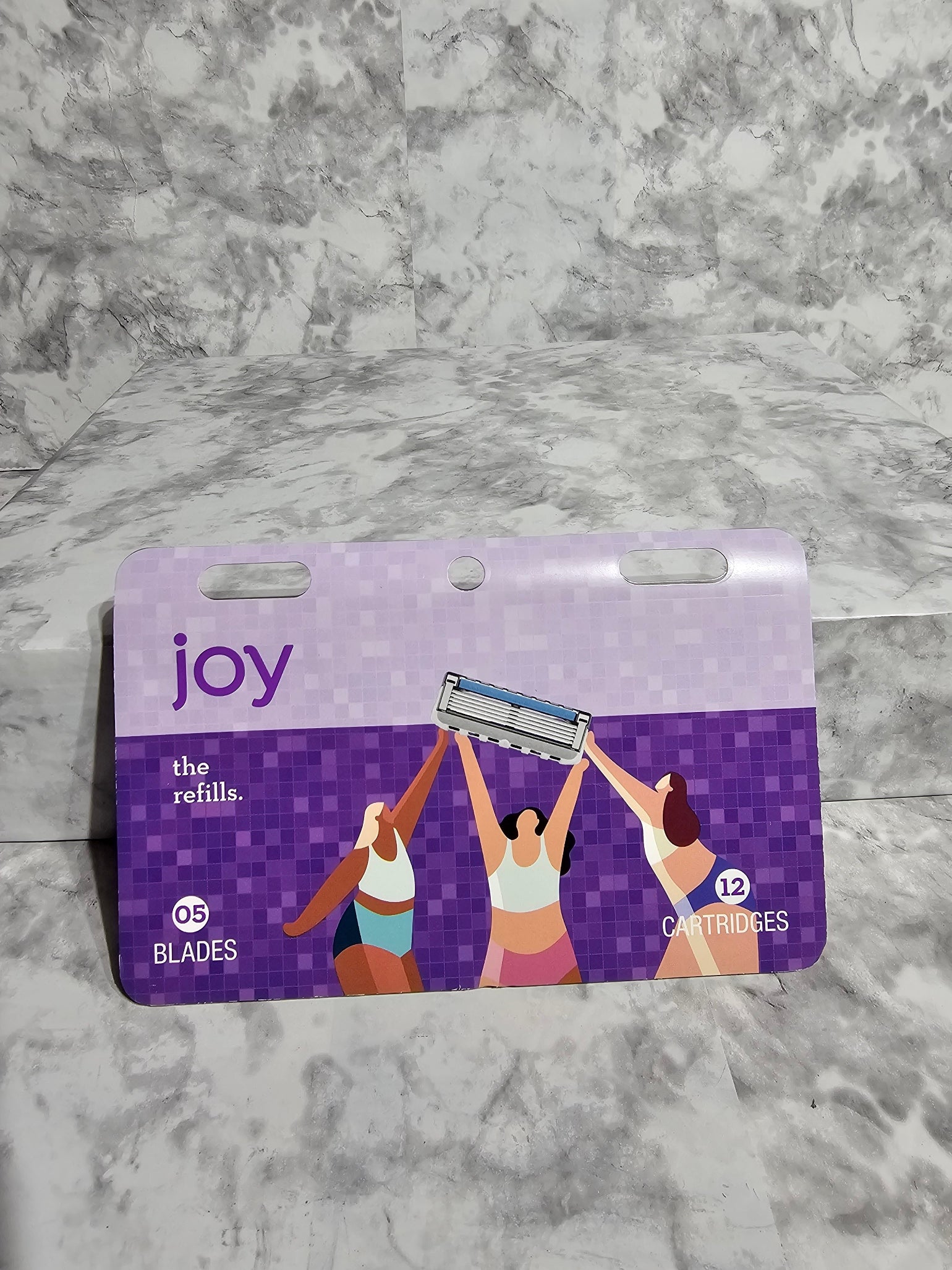 Purple packaging of a women's hygiene product on a marble surface