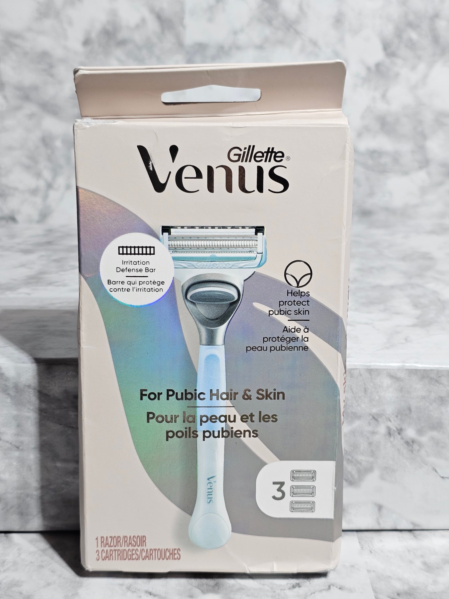 Gillette Venus packaging for public hair and skin on a marble surface