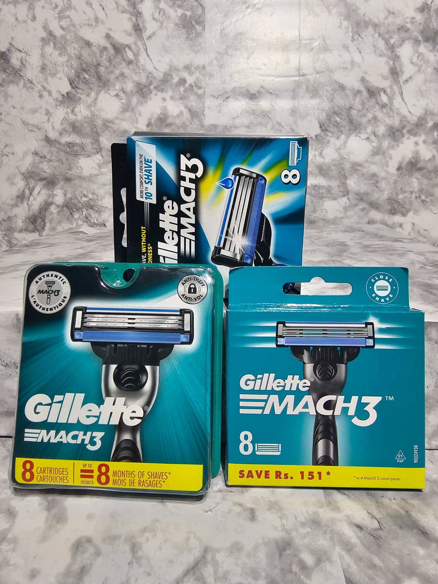 Three packages of Gillette Mach3 razors on a gray marble surface