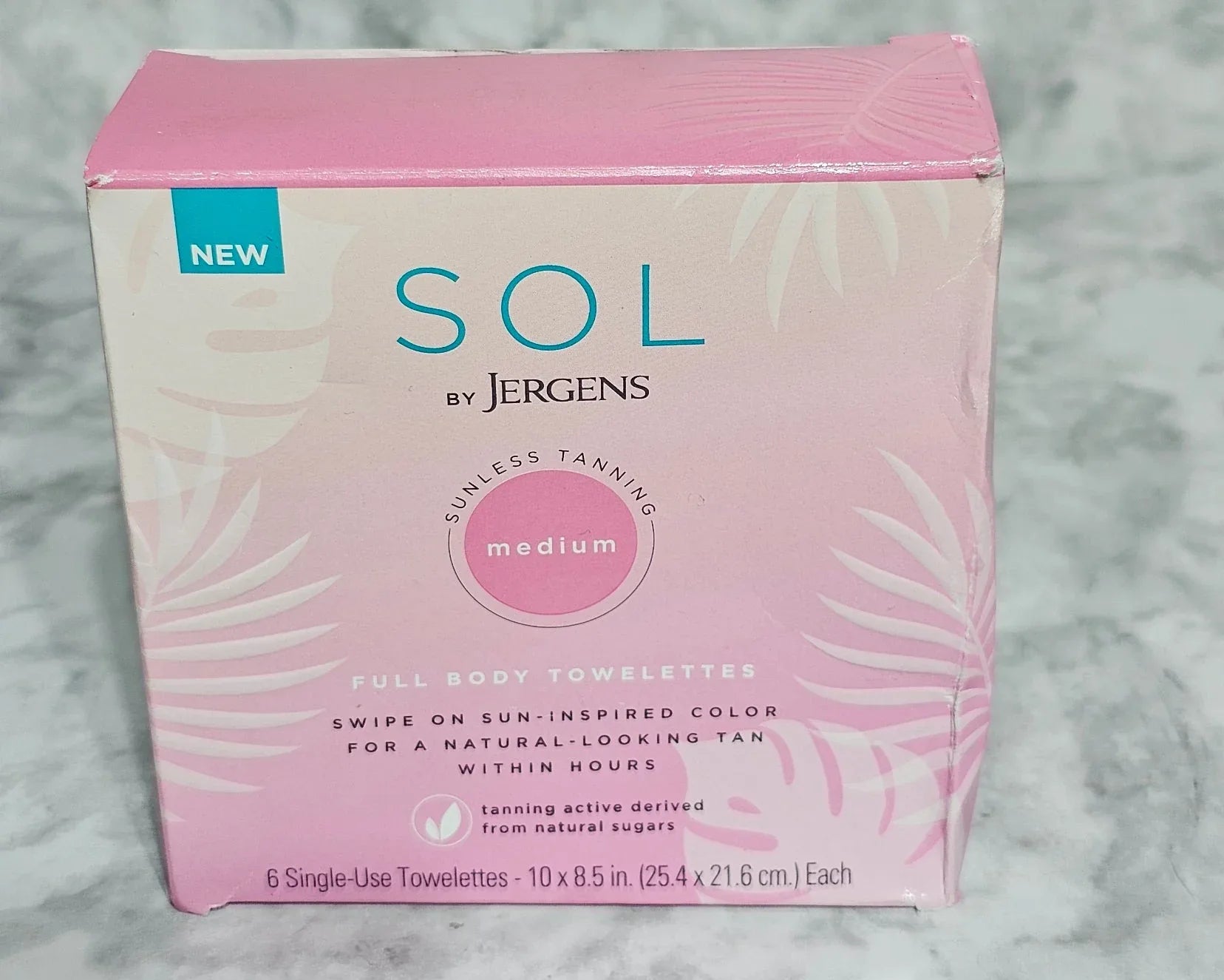 Pink and white box with 'SOL' branding on a gray marble background