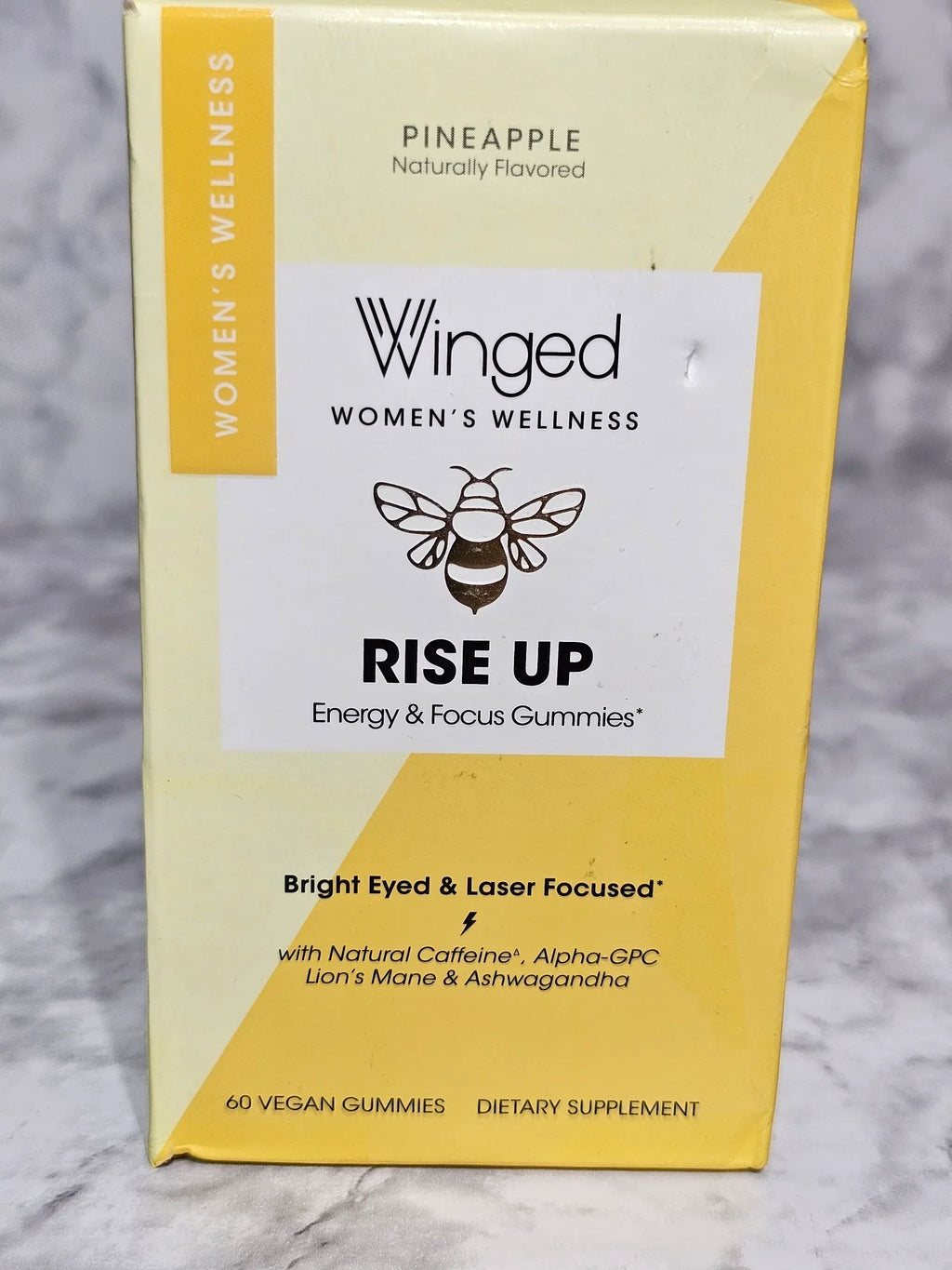 Box of Winged Women's Wellness 'Rise Up' gummies on a marble surface