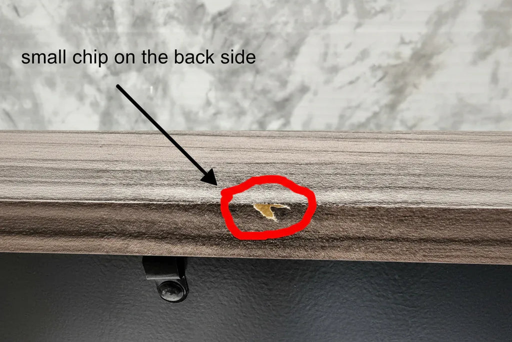 Close-up of a door with a small hole and a gold object inside, next to a marble surface.