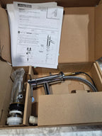 Faucet in an open cardboard box with installation instructions.