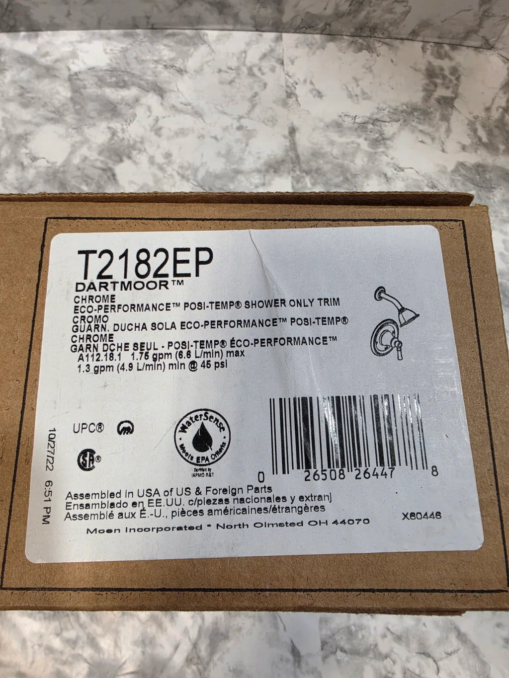 Product label with barcode and text on a cardboard backing against a marble background